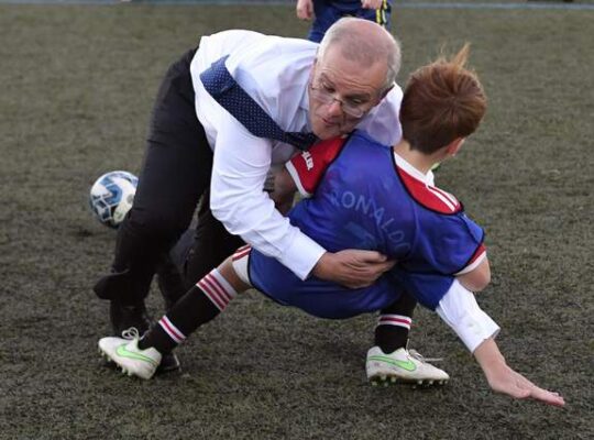 Strategic Australian President Rough Tackles Boy On Football Field For Election Promo